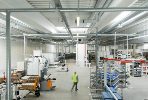 Person in an industrial or production hall.